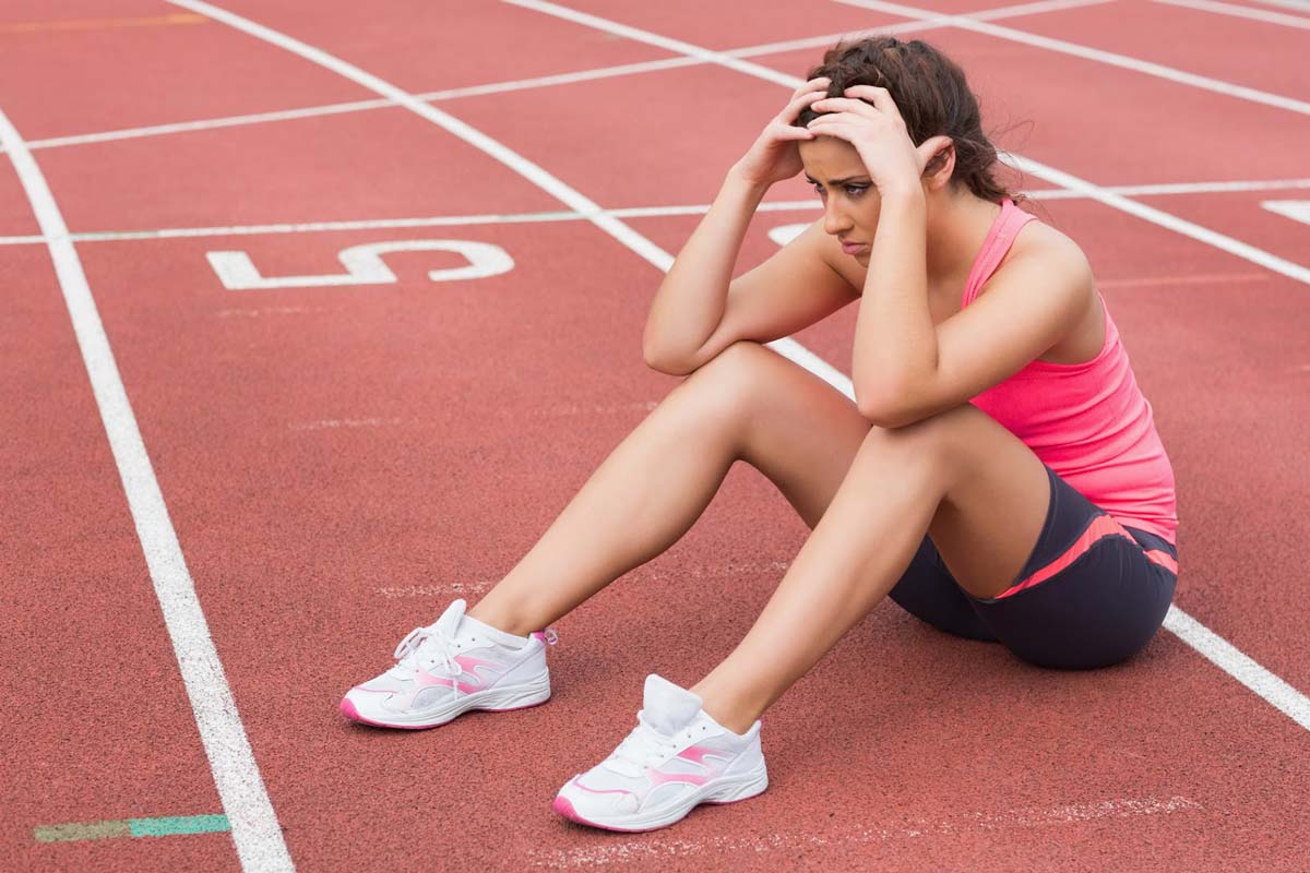 Tired runner sitting on an athletics track