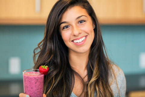 Woman holding a berry smoothie