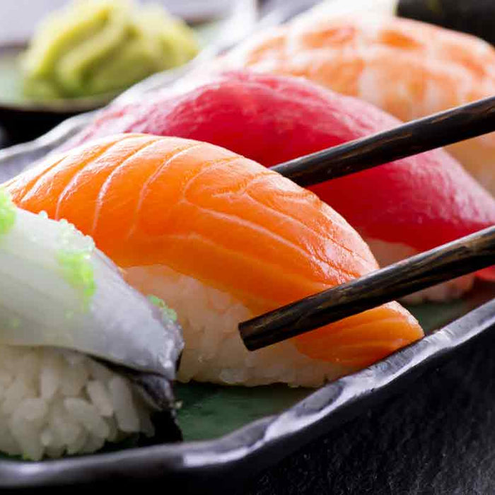 Sushi pieces held with chopsticks