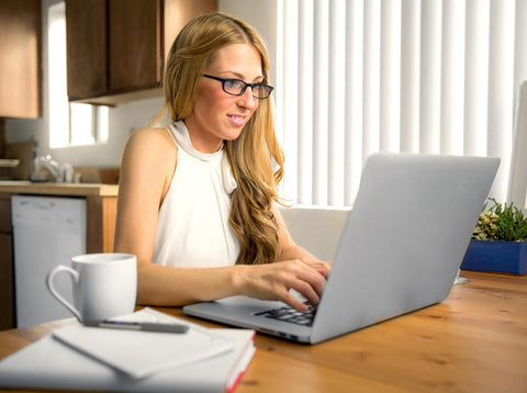 Woman using a laptop at a kitchen table