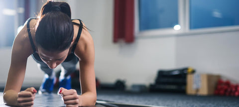 Woman doing a forearm plank during a gym workout