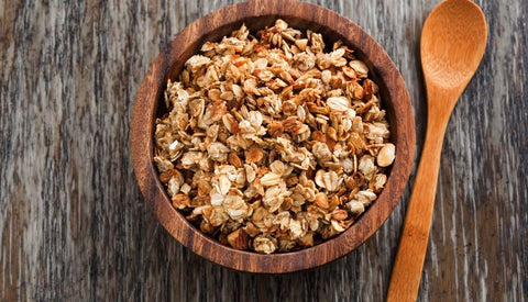Bowl of granola with a wooden spoon
