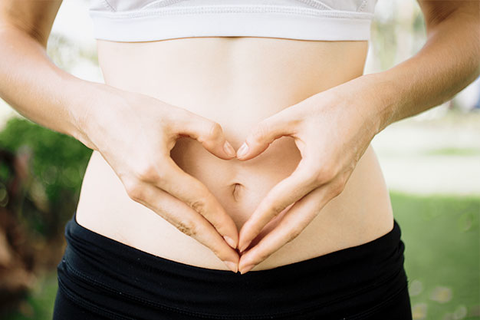 Hands forming a heart over the stomach