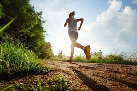 Runner training on a woodland path