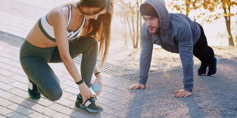 Two people tying their running shoes before exercising